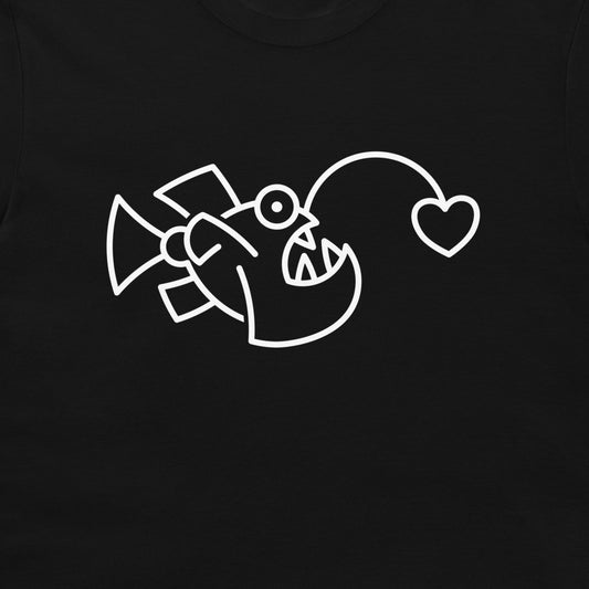 A close-up of a black t-shirt, featuring a white line art graphic of an angler fish with a heart-shaped lure.