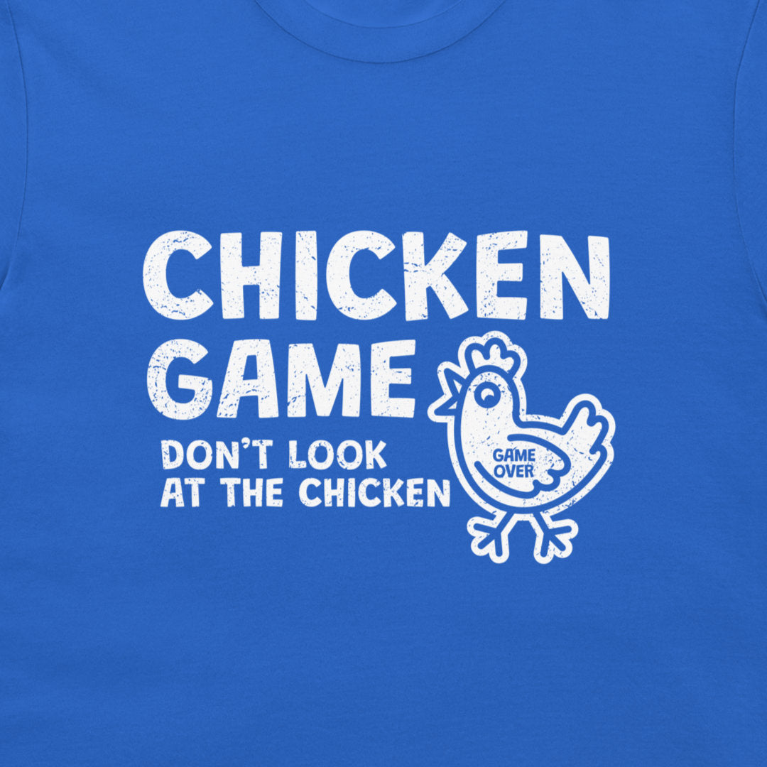 A close-up of a bright blue t-shirt featuring a white distressed graphic print that reads 'CHICKEN GAME DON'T LOOK AT THE CHICKEN' alongside a cartoon chicken with 'GAME OVER' written inside it.