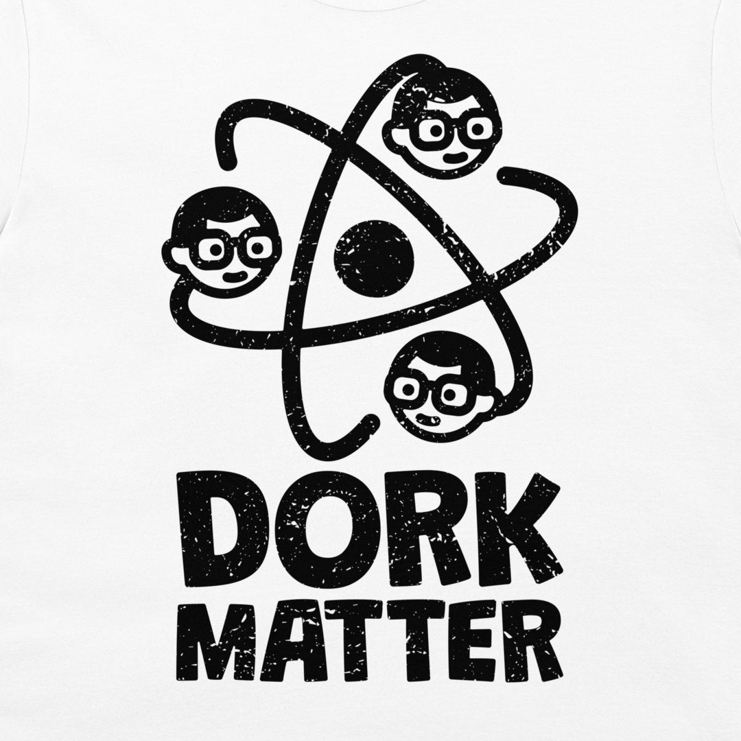 A white t-shirt featuring a black distressed graphic of three cartoon dork faces orbiting an atom symbol, with the text 'DORK MATTER' printed below in a bold, distressed font.
