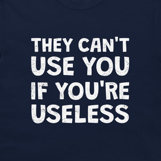 A close-up of a navy blue t-shirt featuring a bold, distressed white text graphic that reads 'THEY CAN'T USE YOU IF YOU'RE USELESS'.