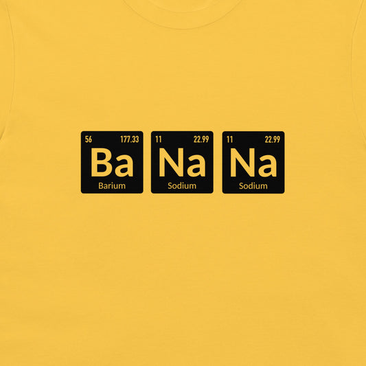 A close-up of a bright yellow t-shirt, featuring a graphic print of three black periodic table style tiles spelling out 'Ba Na Na' in yellow, with 'Barium' and 'Sodium' written below.