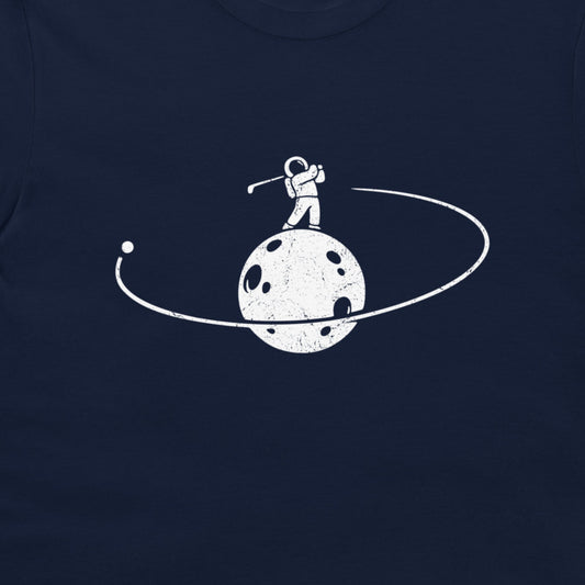 A close-up of a navy blue t-shirt featuring a distressed white graphic of an astronaut standing on a cratered moon with a ring around it.