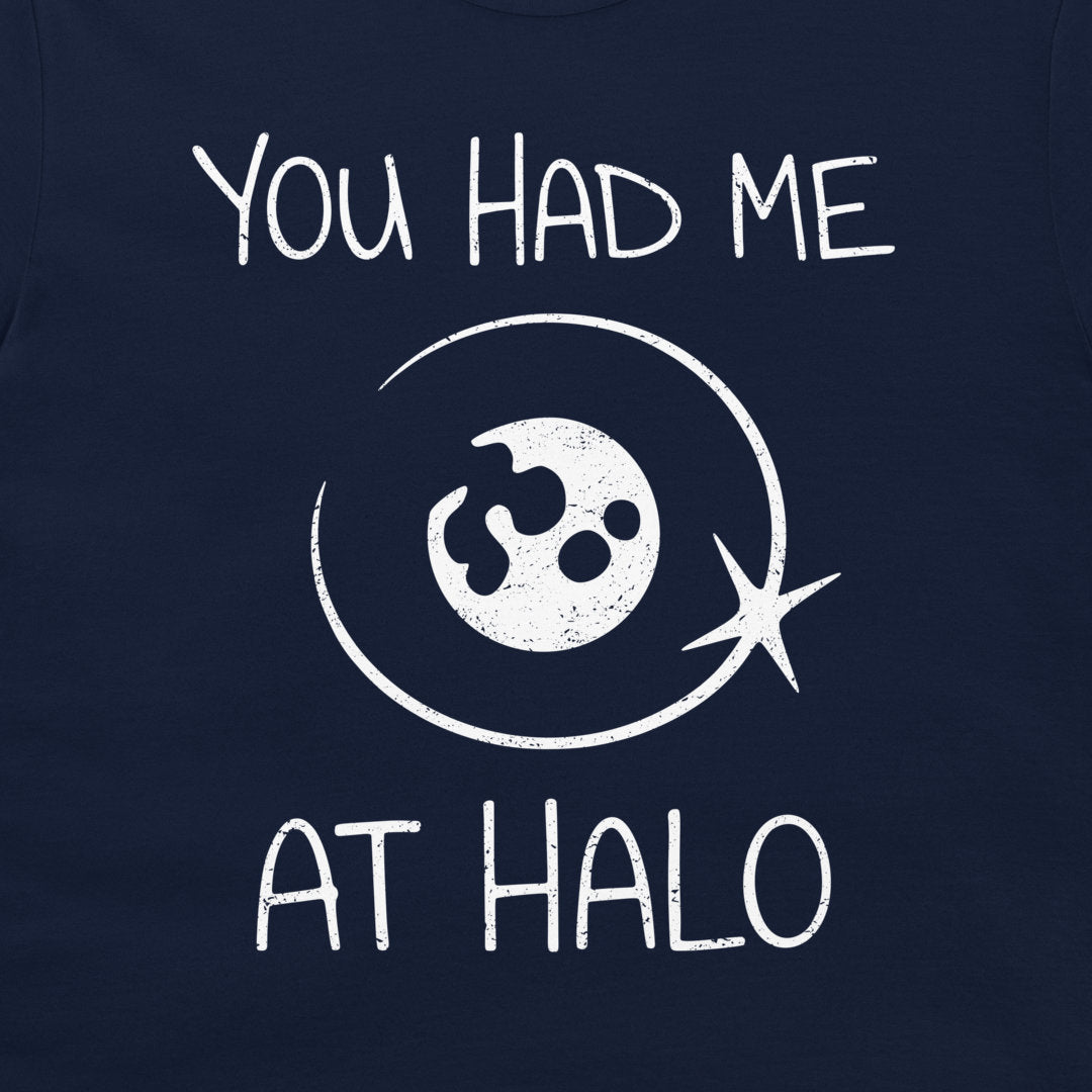 A close-up of a navy blue t-shirt, featuring a white distressed graphic print that reads 'YOU HAD ME AT HALO' around a stylized moon with a halo around.