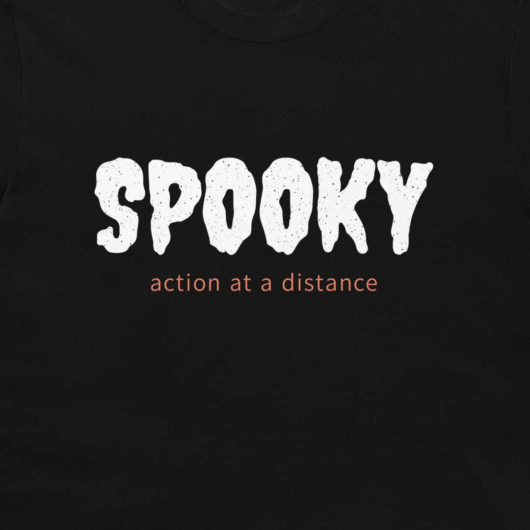 Close-up of white SPOOKY lettering and orange action at a distance text on a black T-shirt.