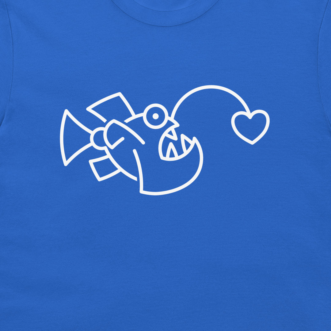 A close-up of a bright blue t-shirt, featuring a white minimalist line art graphic of a fish with a heart-shaped mouth.