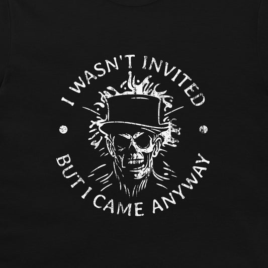 A close-up of a black garment featuring a distressed white graphic print of a skull wearing a top hat, surrounded by the text 'I WASN'T INVITED BUT I CAME ANYWAY'.