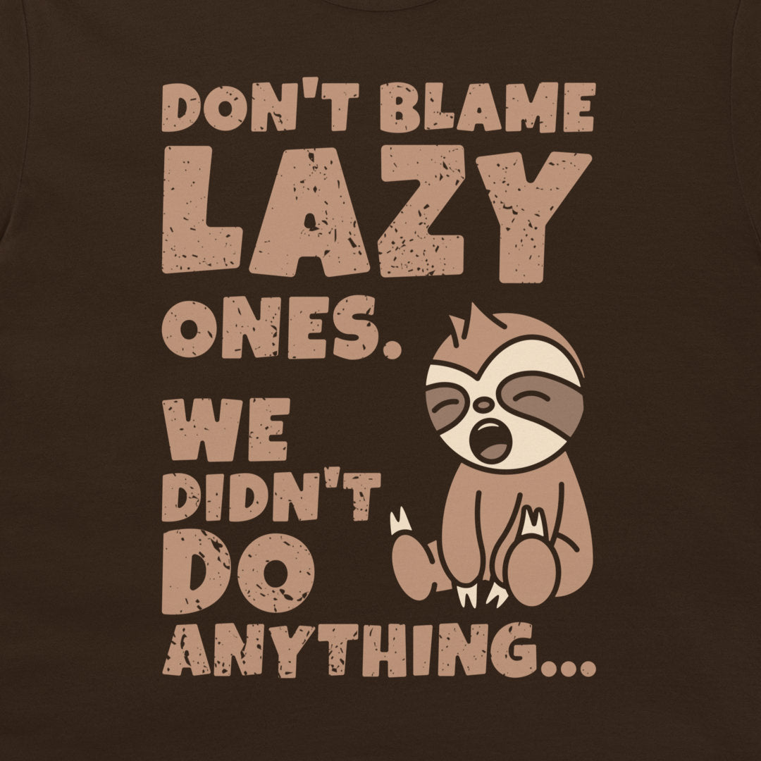 A dark chocolate graphic t-shirt featuring a distressed beige print that reads 'DON'T BLAME LAZY ONES. WE DIDN'T DO ANYTHING.