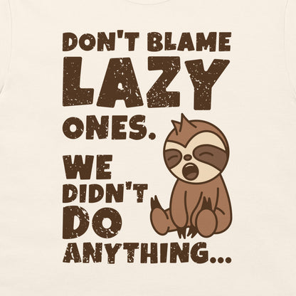 A natural graphic t-shirt featuring a distressed beige print that reads 'DON'T BLAME LAZY ONES. WE DIDN'T DO ANYTHING.
