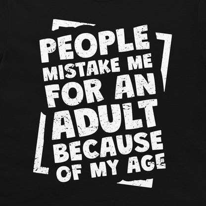 A close-up of a black garment, likely a t-shirt, featuring a distressed white graphic print with the text 'PEOPLE MISTAKE ME FOR AN ADULT BECAUSE OF MY AGE'.
