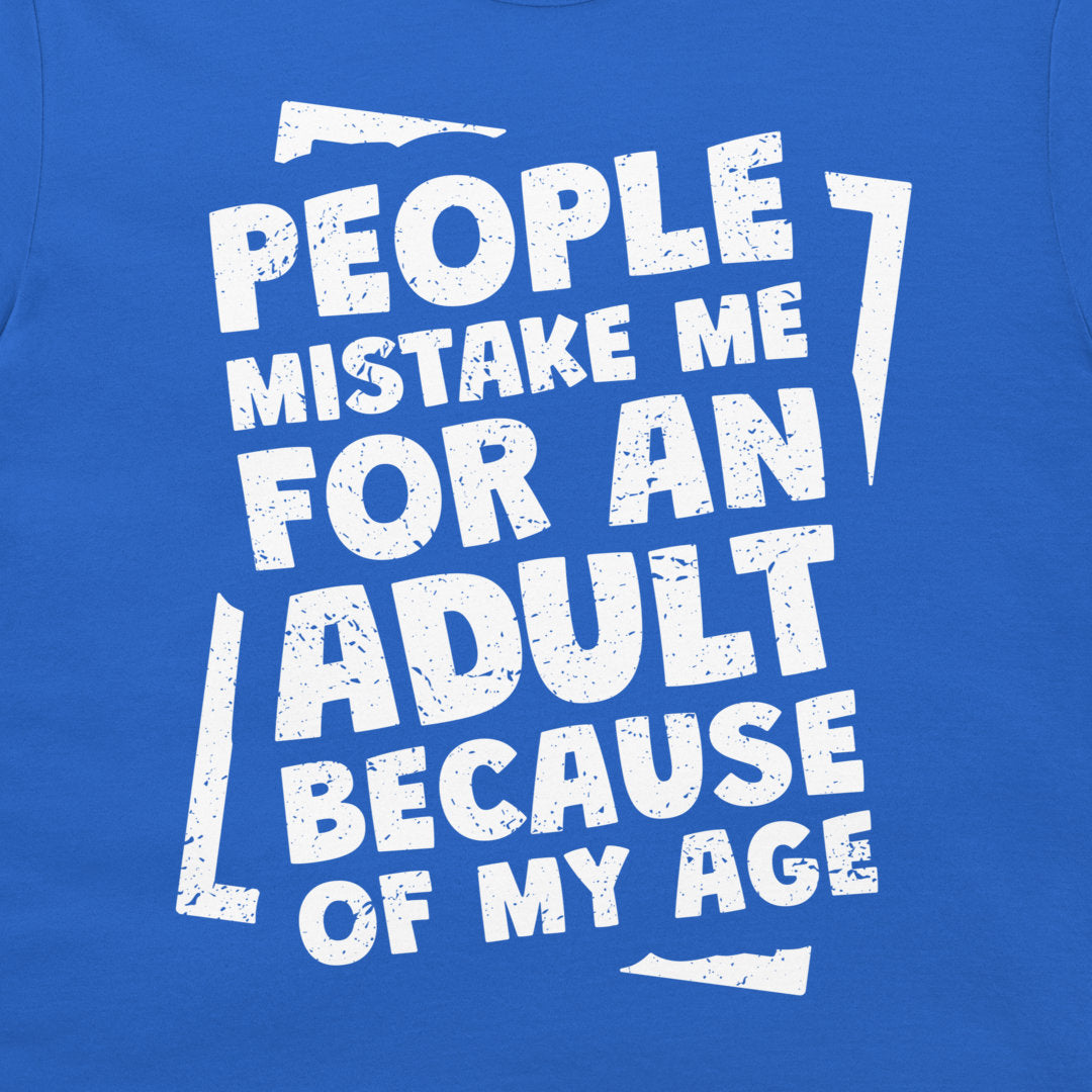 A close-up of a blue graphic t-shirt featuring distressed white text that reads 'PEOPLE MISTAKE ME FOR AN ADULT BECAUSE OF MY AGE' framed by abstract white graphic shapes.