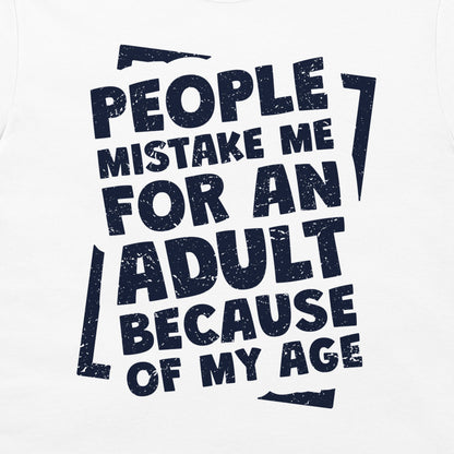 A close-up of a white t-shirt featuring a bold, distressed navy blue graphic print with the text 'PEOPLE MISTAKE ME FOR AN ADULT BECAUSE OF MY AGE'.