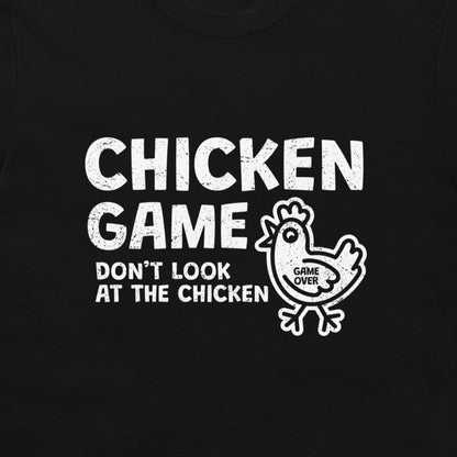 A close-up of a black t-shirt featuring a distressed white graphic print that reads 'CHICKEN GAME DON'T LOOK AT THE CHICKEN' alongside a cartoon chicken with 'GAME OVER' written inside it.