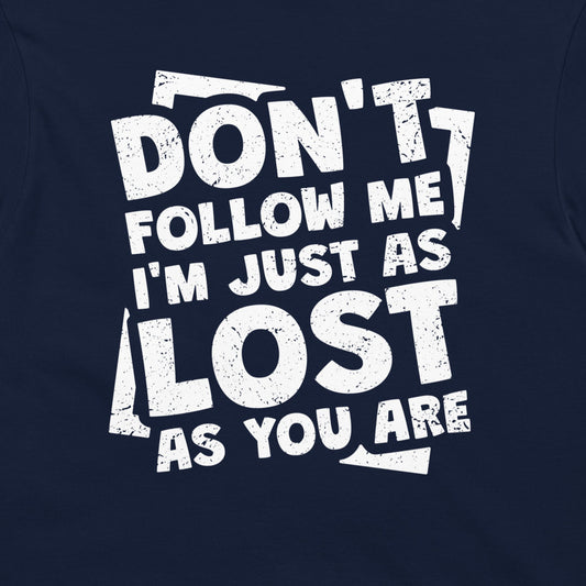 A close-up of a navy blue t-shirt, featuring a distressed white graphic print that reads 'DON'T FOLLOW ME I'M JUST AS LOST AS YOU ARE'.