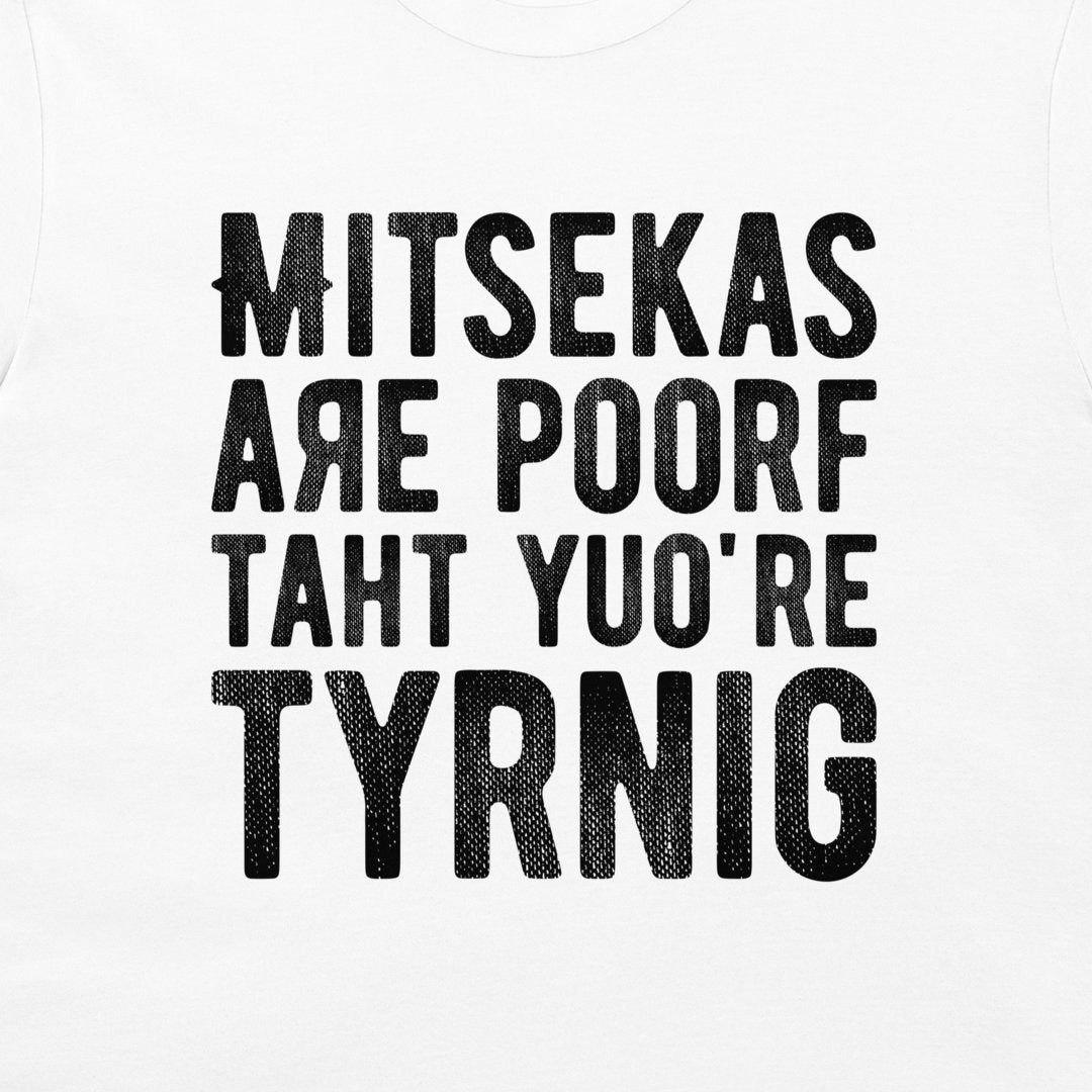 White t-shirt with a black distressed text graphic reading 'MITSEKAS ARE POORF TAHT YU'O'RE TYRNIG' in a bold, stylized font.