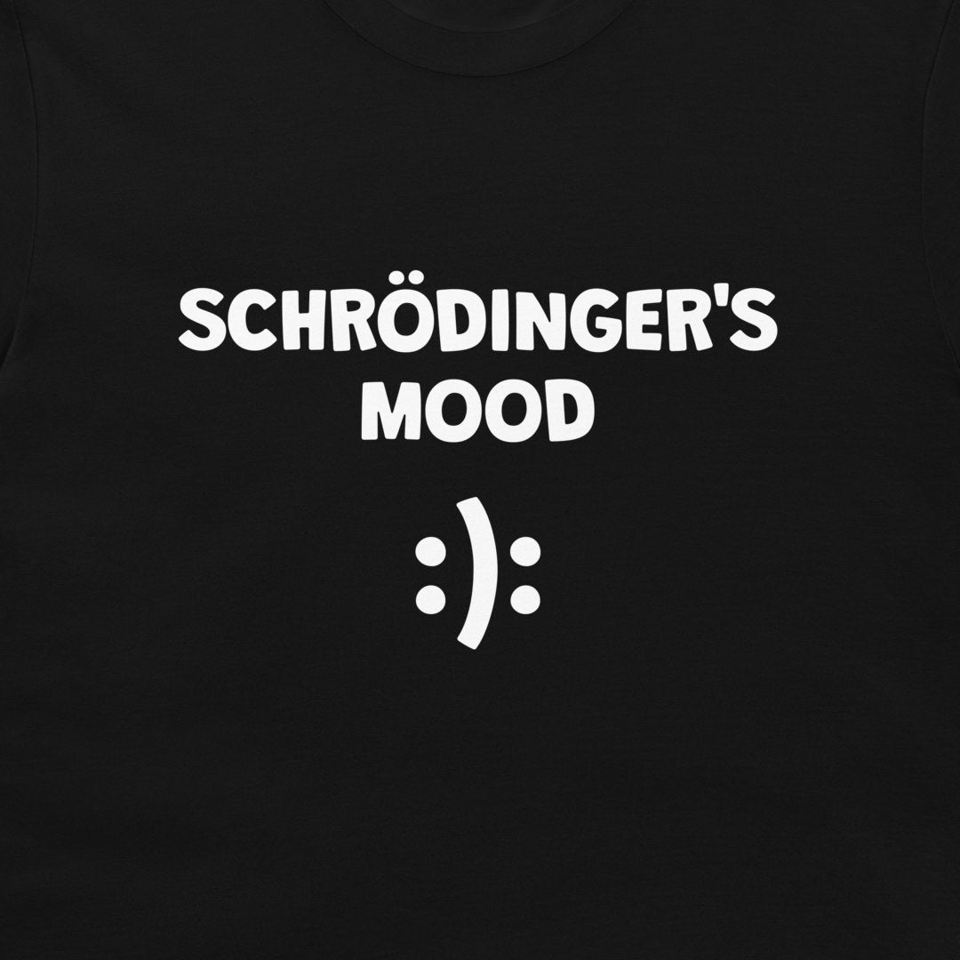 A close-up of a black t-shirt featuring the white printed text 'SCHRÖDINGER'S MOOD' above a white smiley face symbol.