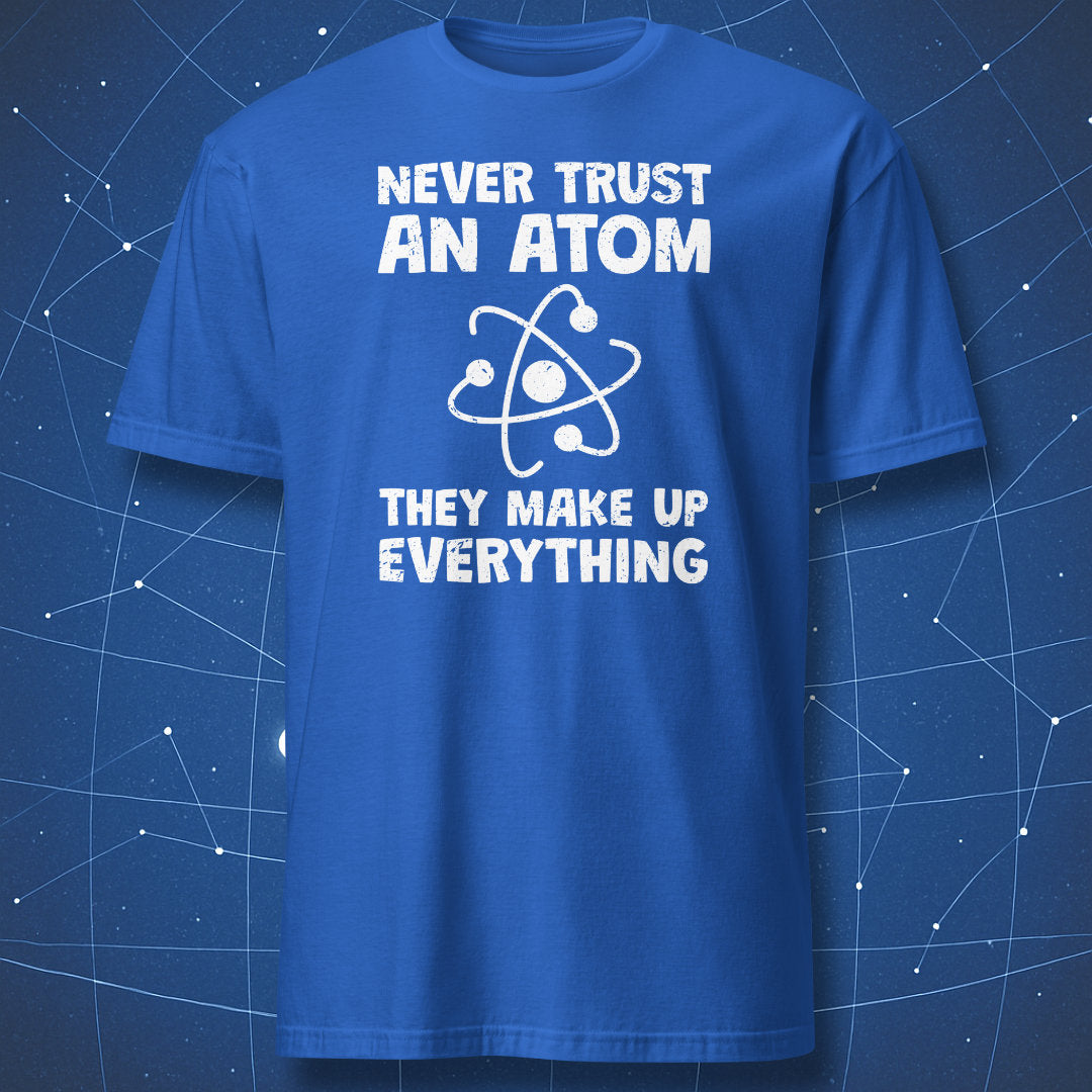 funny science T-shirt on white fabric featuring an atom graphic and text “Never Trust an Atom – They Make Up Everything” in bold distressed lettering