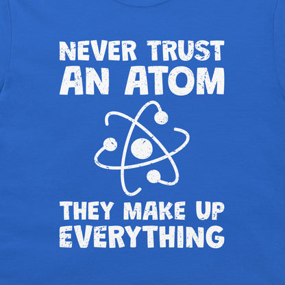 A close-up of a blue T-shirt or sweatshirt featuring a white distressed graphic that reads 'NEVER TRUST AN ATOM THEY MAKE UP EVERYTHING' with an atom symbol in the center.