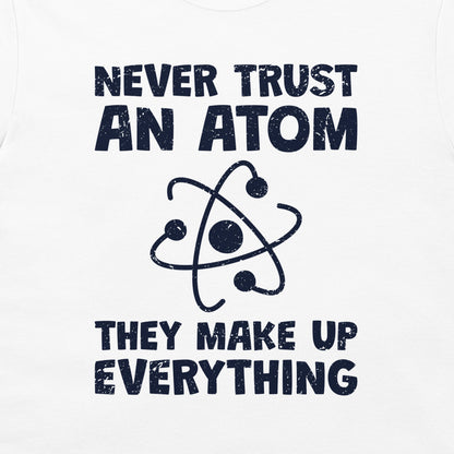 White tank top featuring a dark navy blue graphic print with the text 'NEVER TRUST AN ATOM THEY MAKE UP EVERYTHING' and a stylized atom icon.