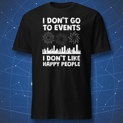 funny introvert T-shirt on black fabric with distressed white text reading I Don’t Go to Events I Don’t Like Happy People and city skyline with fireworks
