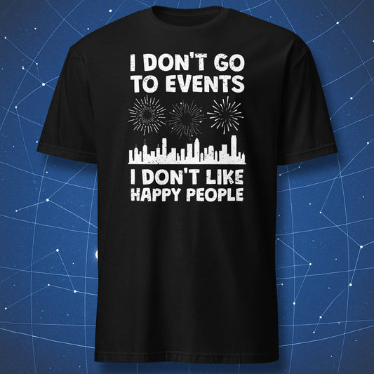 funny introvert T-shirt on black fabric with distressed white text reading I Don’t Go to Events I Don’t Like Happy People and city skyline with fireworks