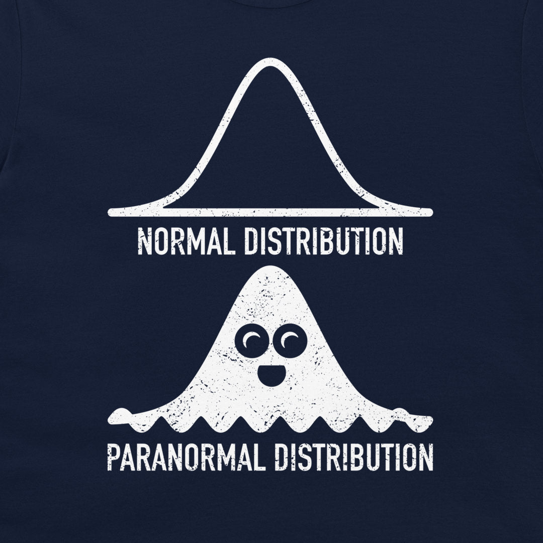 A close-up of a navy blue garment, likely a t-shirt, featuring a white graphic print. The design shows a standard normal distribution curve labeled 'NORMAL DISTRIBUTION' above a cute, cartoonish ghost-like distribution with eyes and a mouth labeled 'PARANORMAL DISTRIBUTION'.