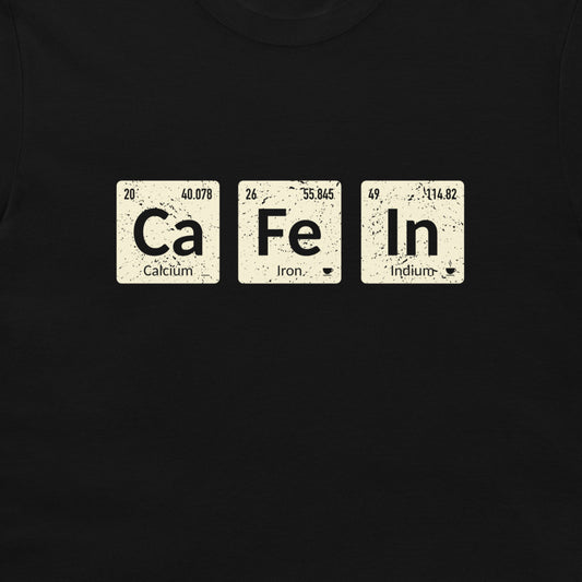 A close-up of a black t-shirt, featuring a graphic print of three distressed cream-colored periodic table tiles spelling out 'Ca Fe In' with 'Calcium', 'Iron', and 'Indium' written below each tile.