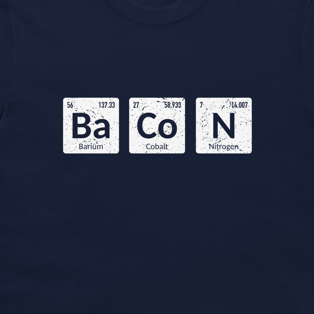 A close-up of a navy blue t-shirt featuring a graphic print of three white periodic table style tiles spelling out 'BaCoN' with the words 'Barium', 'Cobalt', and 'Nitrogen' underneath.