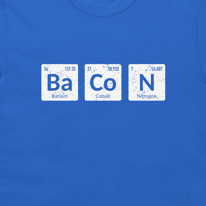 A close-up of a royal blue t-shirt featuring a graphic print of three white periodic table style tiles spelling out 'Ba Co N' with the words 'Barium', 'Cobalt', and 'Nitrogen' underneath, representing the chemical initials for Bacon.