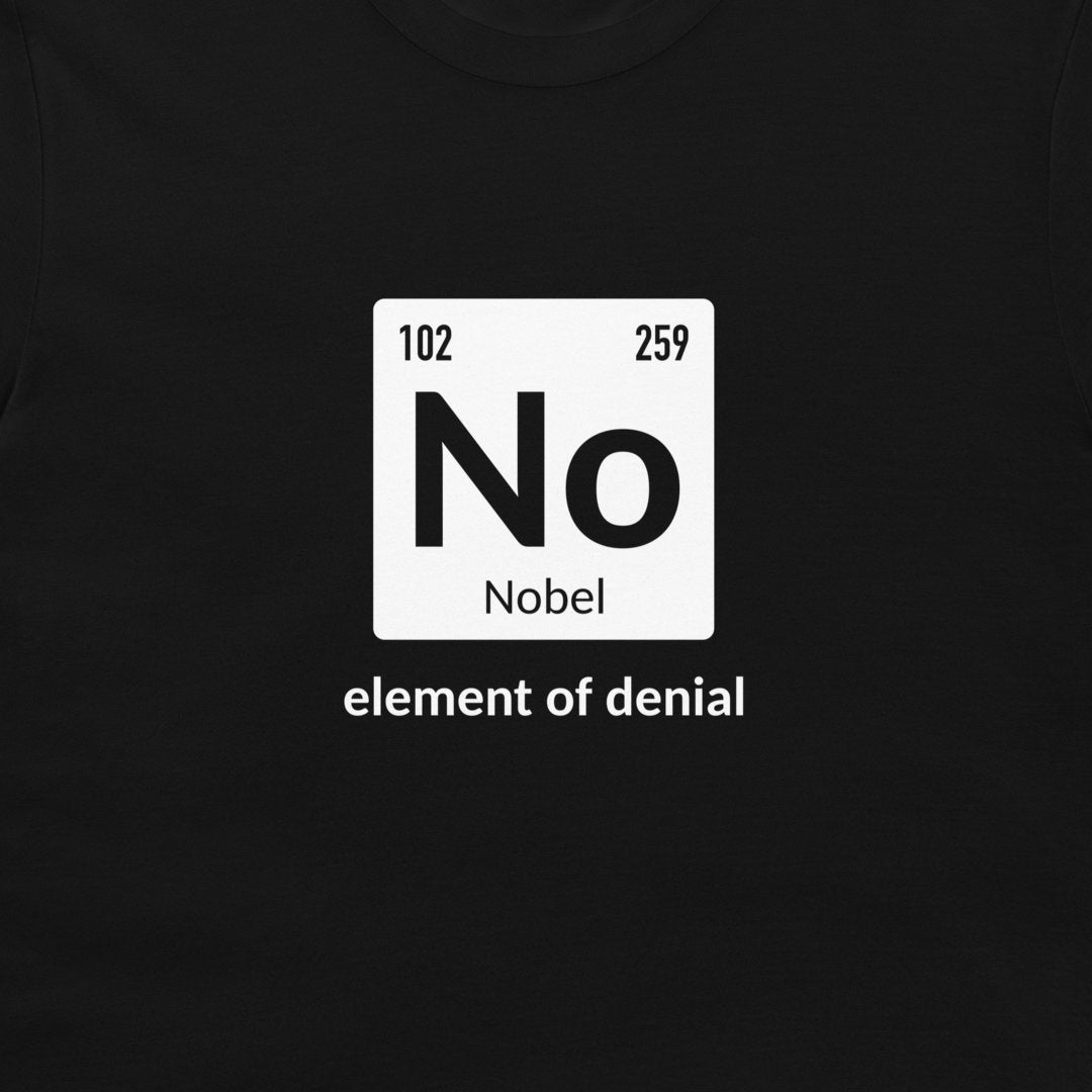 A black t-shirt featuring a white periodic table-style graphic with the word 'No' and 'Nobel' underneath, plus the phrase 'element of denial' printed below in white text.