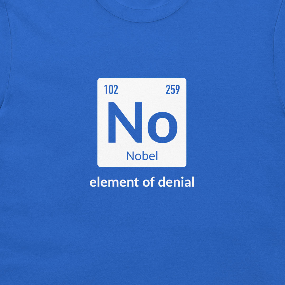 A close-up of a blue crewneck t-shirt featuring a white square graphic styled like a periodic table element with the letter 'No' and the name 'Nobel', with the phrase 'element of denial' printed below in white.