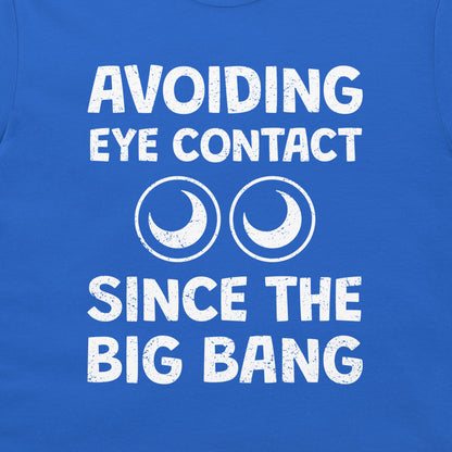 A close-up of a royal blue t-shirt featuring a white distressed graphic that reads 'AVOIDING EYE CONTACT SINCE THE BIG BANG' with two crescent moon circle icons.