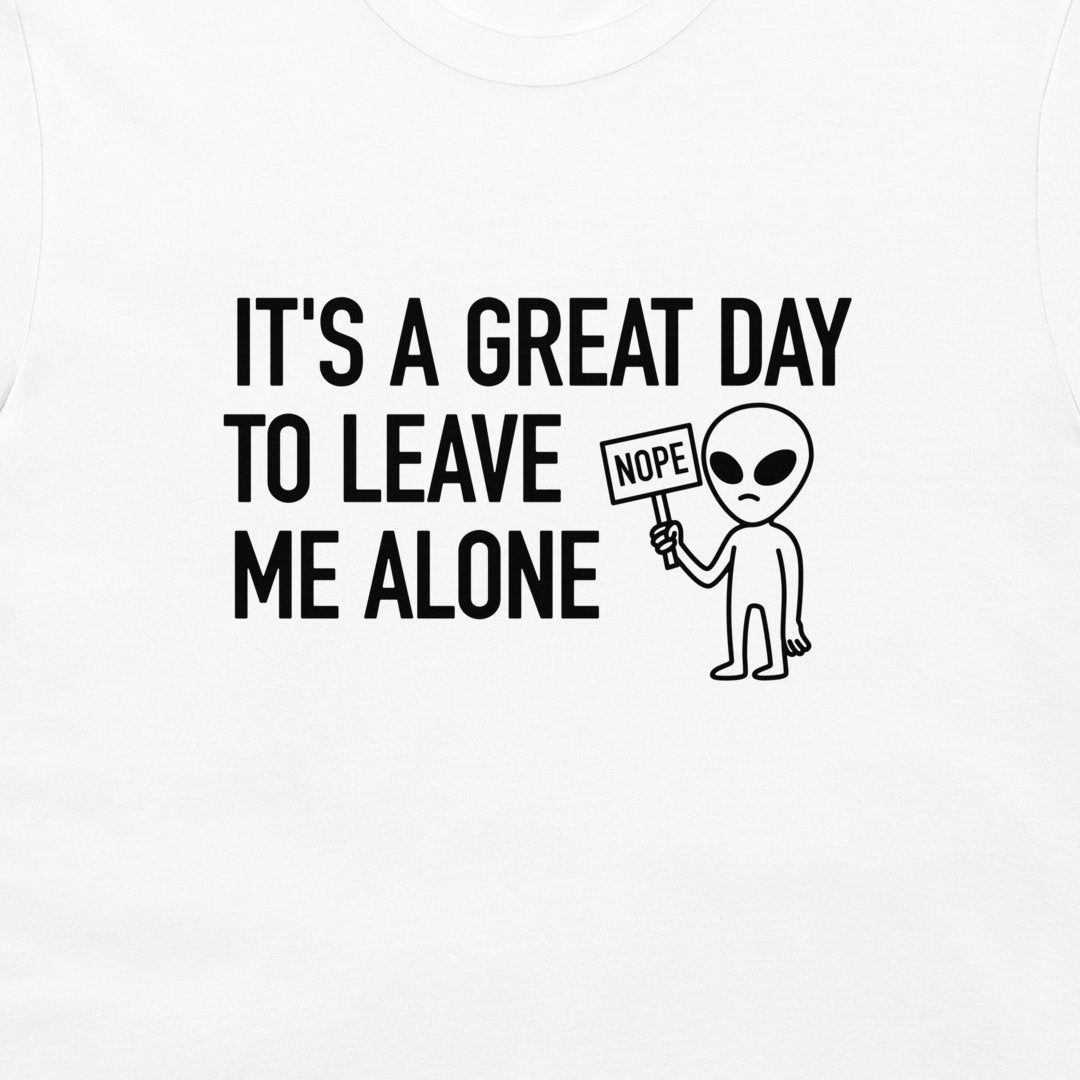 White t-shirt with a black graphic print that reads 'IT'S A GREAT DAY TO LEAVE ME ALONE' next to a cartoon alien holding a 'NOPE' sign.