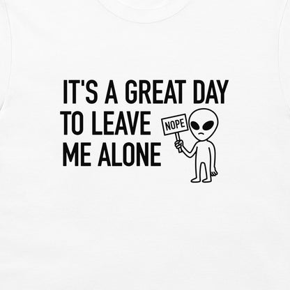 White t-shirt with a black graphic print that reads 'IT'S A GREAT DAY TO LEAVE ME ALONE' next to a cartoon alien holding a 'NOPE' sign.