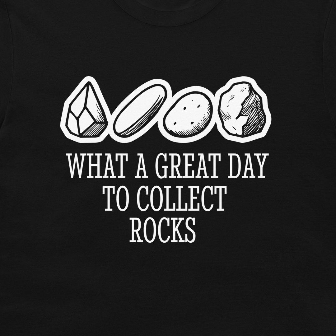 A close-up of a black t-shirt featuring a white graphic print of four different rocks and the text 'WHAT A GREAT DAY TO COLLECT ROCKS'.
