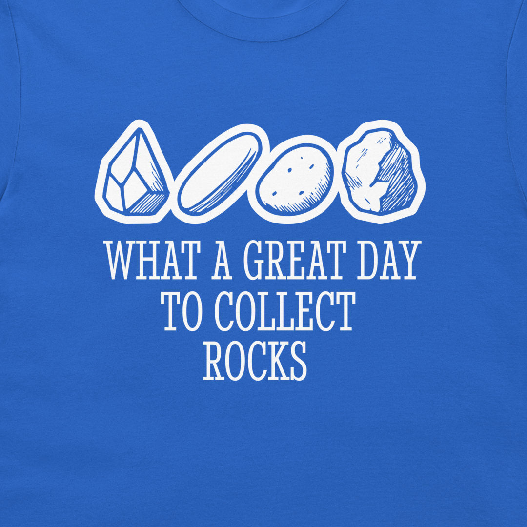 A close-up of a royal blue t-shirt featuring a white graphic print of four different rocks and the text 'WHAT A GREAT DAY TO COLLECT ROCKS'.