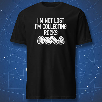 nerdy geologist T-shirt on black background featuring white text “I’m not lost I’m collecting rocks” and sketches of stones