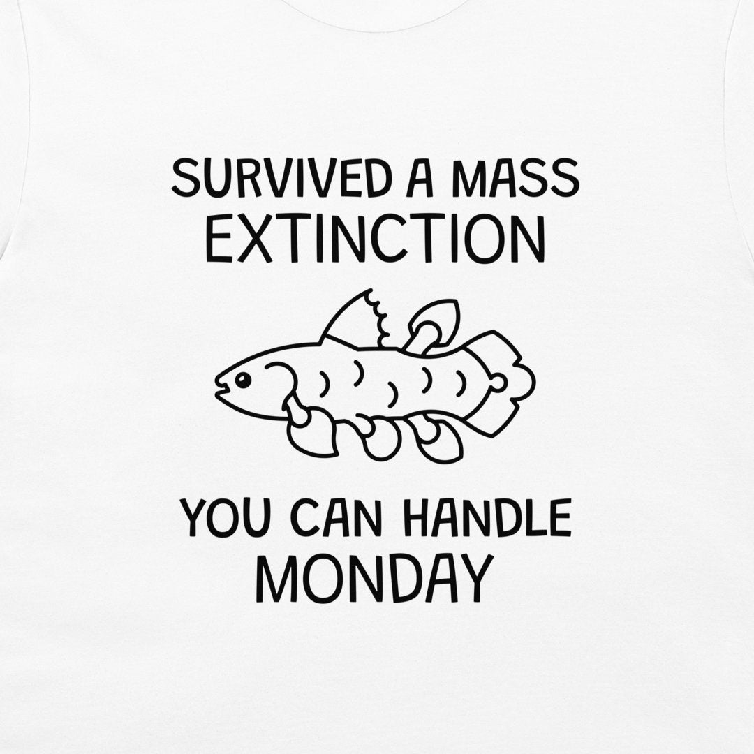 White t-shirt featuring a black graphic print with the text 'SURVIVED A MASS EXTINCTION YOU CAN HANDLE MONDAY' and a simple line drawing of a fish.