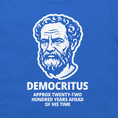 A close-up of a royal blue t-shirt featuring a white distressed graphic of Democritus' portrait with the text 'DEMOCRITUS APPROX TWENTY-TWO HUNDRED YEARS AHEAD OF HIS TIME'.
