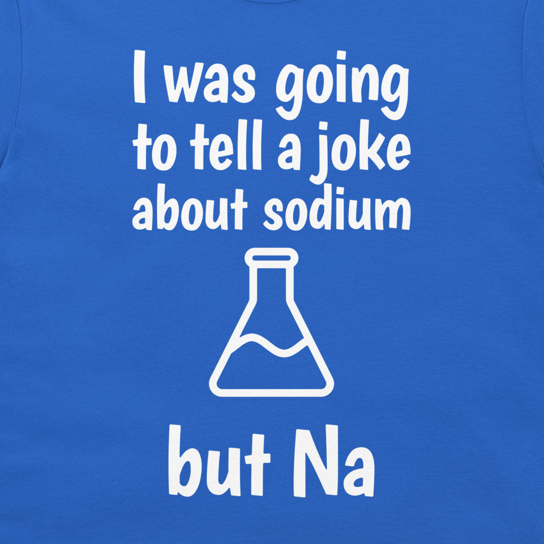A close-up of a blue T-shirt with white printed text reading 'I was going to tell a joke about sodium but Na' and a white flask outline graphic.