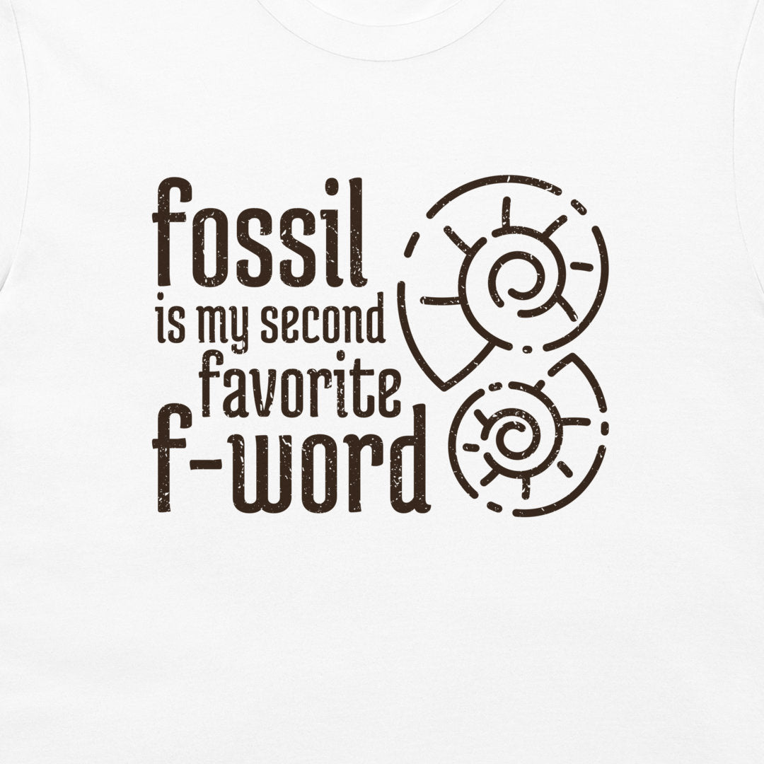White t-shirt featuring a dark brown graphic print that reads 'fossil is my second favorite f-word' alongside two spiral ammonite illustrations.