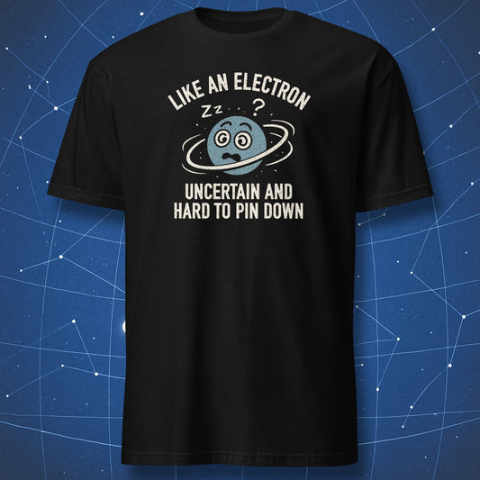 Black T-shirt with cartoon electron surrounded by orbit rings and text “Like an electron – uncertain and hard to pin down.” Funny science humor shirt.