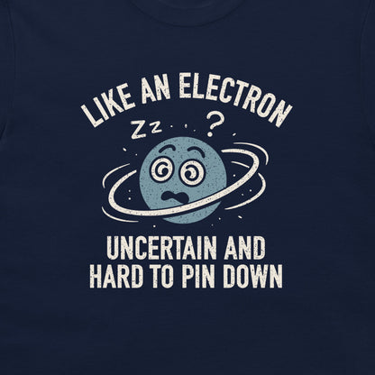 A close-up of a navy blue t-shirt featuring a white and light blue graphic of a sleeping planet with the text 'LIKE AN ELECTRON UNCERTAIN AND HARD TO PIN DOWN'.