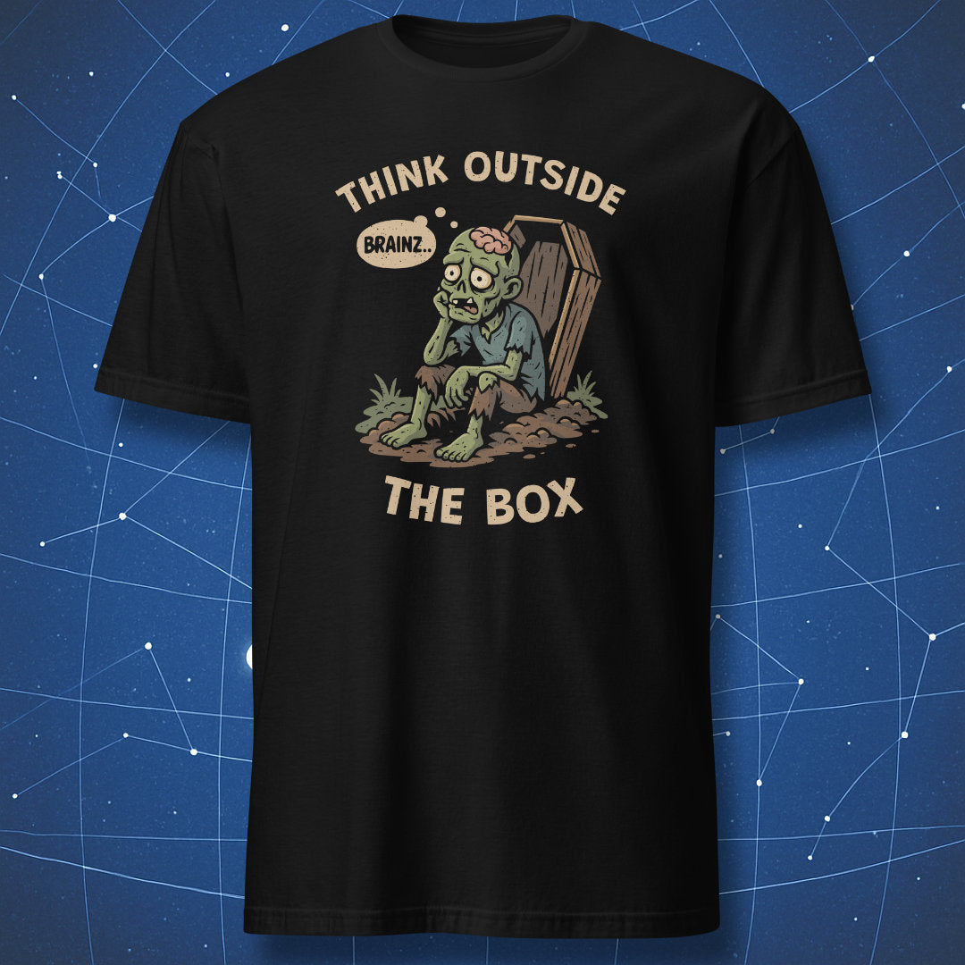 Black T-shirt showing a cartoon zombie sitting outside a coffin, thinking “Brainz…” with text “Think Outside the Box” — funny Halloween dark humor shirt.