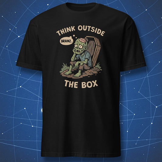 Black T-shirt showing a cartoon zombie sitting outside a coffin, thinking “Brainz…” with text “Think Outside the Box” — funny Halloween dark humor shirt.