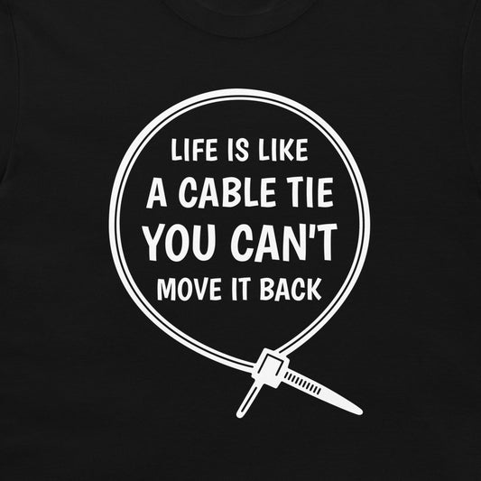 A close-up of a black t-shirt, featuring a white graphic print of a cable tie inside a circle with the humorous quote 'LIFE IS LIKE A CABLE TIE YOU CAN'T MOVE IT BACK'.