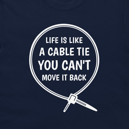 A close-up of a navy blue t-shirt, featuring a white graphic print of a cable tie inside a circle with the humorous quote 'LIFE IS LIKE A CABLE TIE YOU CAN'T MOVE IT BACK'.