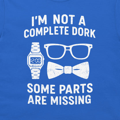 A close-up of a royal blue t-shirt featuring a white distressed graphic that reads 'I'M NOT A COMPLETE DORK SOME PARTS ARE MISSING' with illustrations of a digital watch, eyeglasses, and a bow tie.