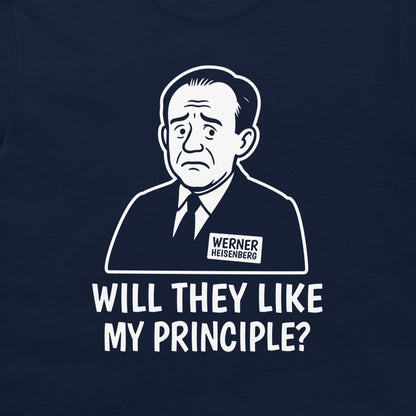 A close-up of a navy blue t-shirt featuring a white graphic print of a caricature portrait of Werner Heisenberg with a name tag and the text 'WILL THEY LIKE MY PRINCIPLE?' printed below.