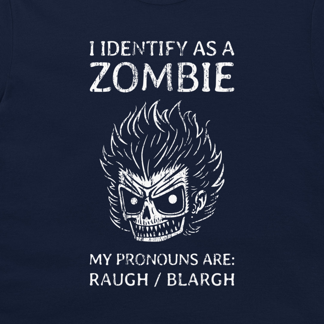 A close-up of a navy blue t-shirt featuring a white graphic print of a skull with wild hair and the text 'I IDENTIFY AS A ZOMBIE MY PRONOUNS ARE: RAUGH / BLARGH'.