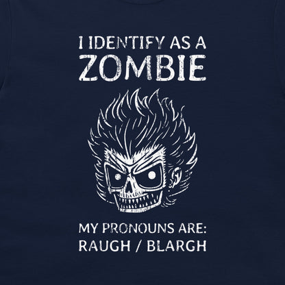 A close-up of a navy blue t-shirt featuring a white graphic print of a skull with wild hair and the text 'I IDENTIFY AS A ZOMBIE MY PRONOUNS ARE: RAUGH / BLARGH'.
